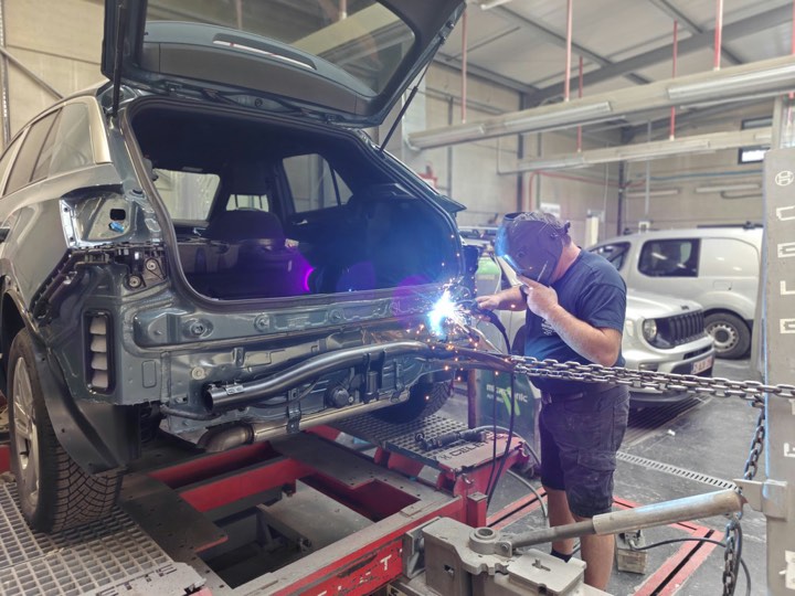 Carrossier last aan de achterkant van een wagen op de richtbank